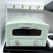a green stove top oven sitting on top of a counter