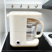 a white coffee maker sitting on top of a counter