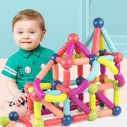 a baby sitting on the floor next to a building set