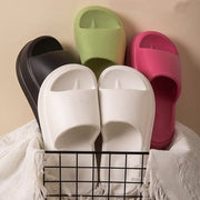 four pairs of slippers sitting on top of a wire rack