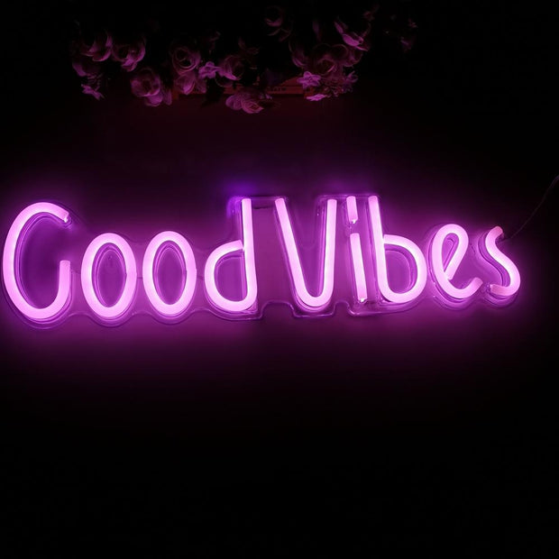 a purple neon sign that says good vibes
