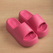 a pair of pink slippers sitting on top of a wooden floor