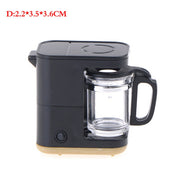 a black coffee maker with a glass cup on top of it